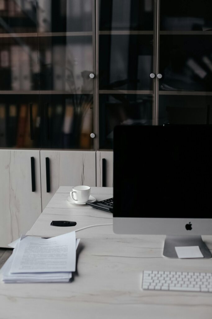 A minimalist office desk setup featuring a computer and documents, perfect for productivity.
